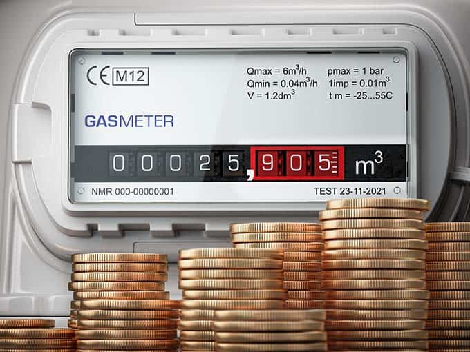 A gas meter with coins in front of it, showing the rise in energy costs